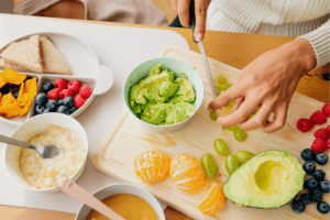 a person cutting fruit on a cutting board
