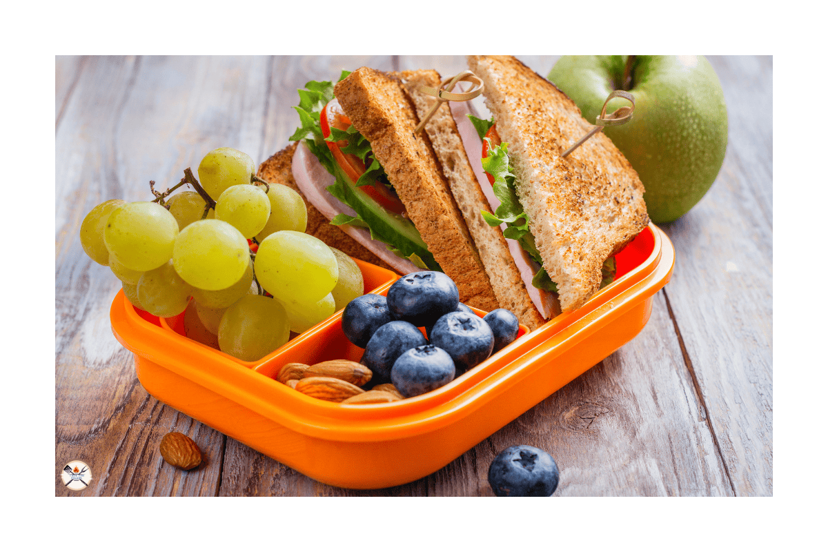 a sandwich and grapes in a container